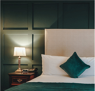 bed with a bedside table with a lamp on it