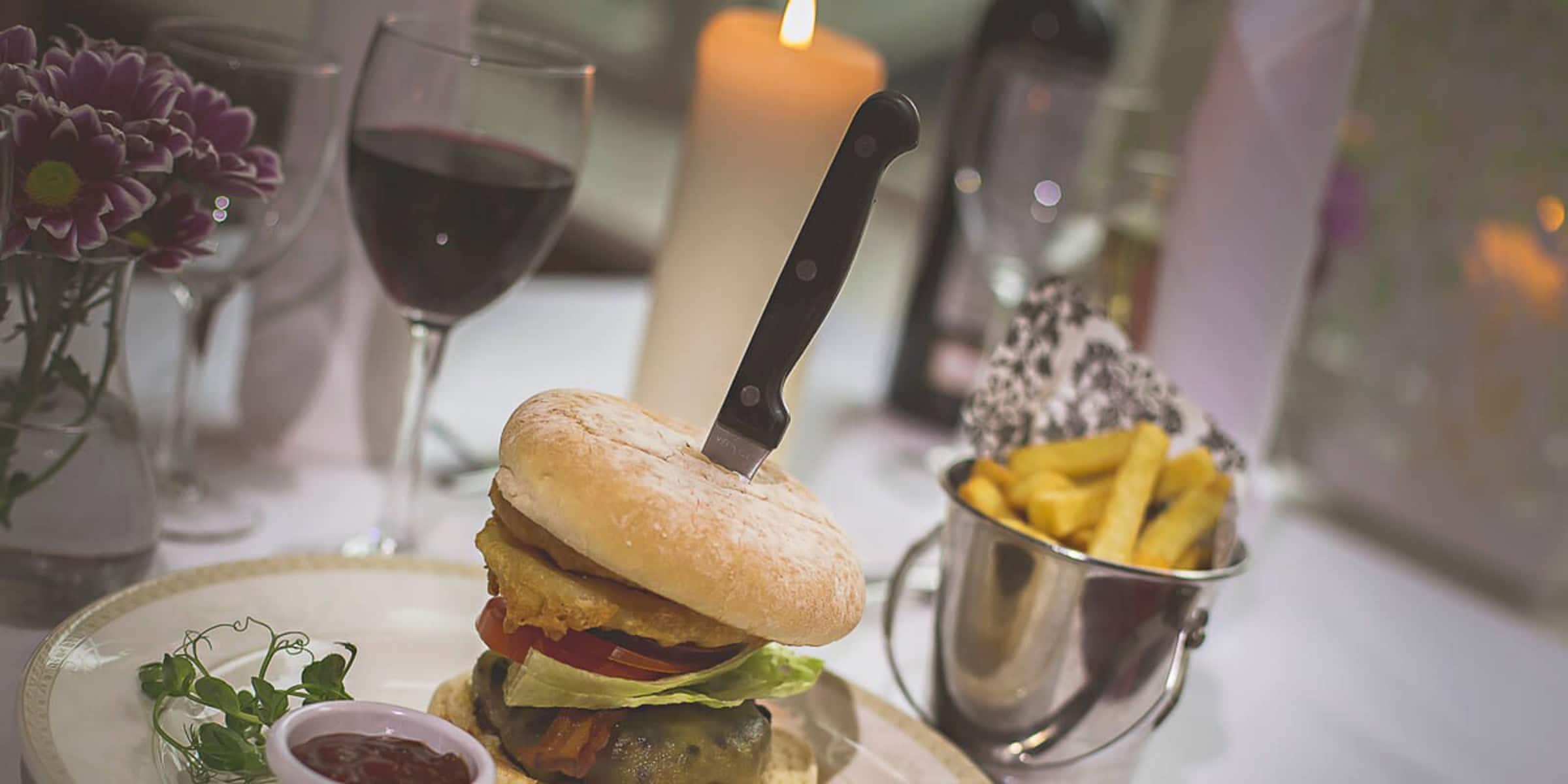 Burger with onion rings and french fries.