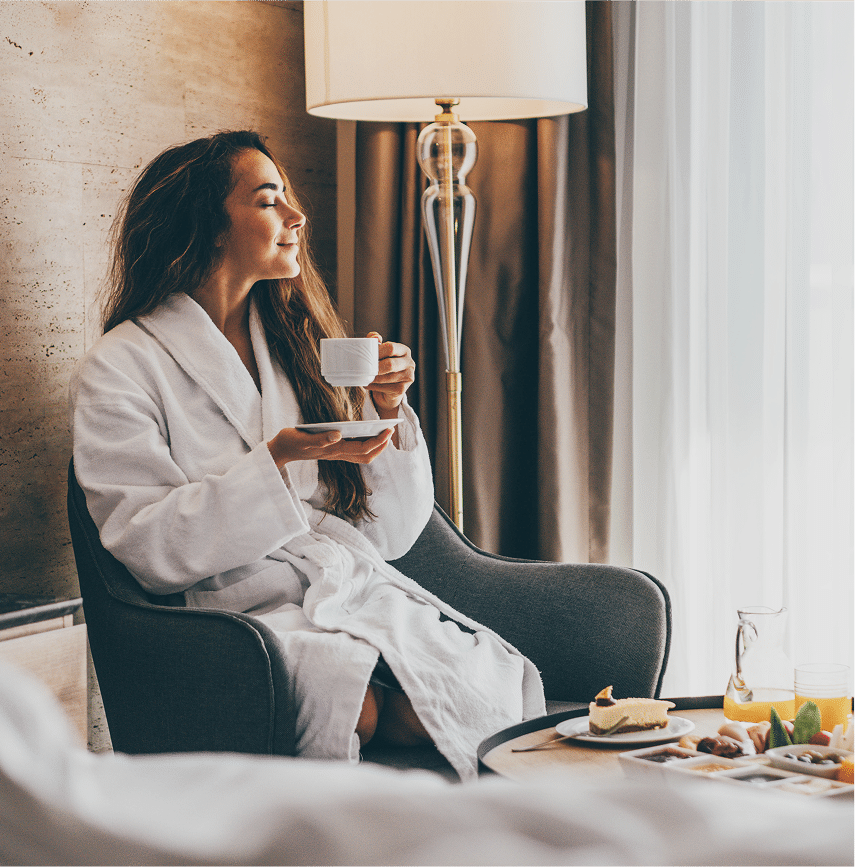 Girl drinking coffee in hotel room